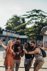 Group of friends taking selfie with a smartphone on a music festival