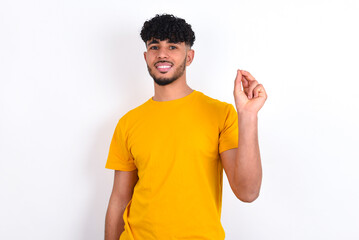 young arab man wearing yellow T-shirt over white background pointing up with hand showing up seven...