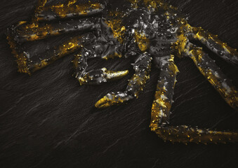 King Crab with lemon and cilantro on black background. Top view.