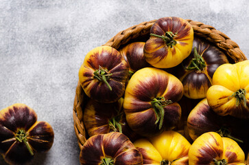 Sart Roloise tomatoes in a basket on a grey background. 