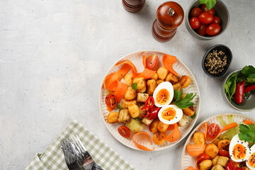 Sweet potato gnocchi with teriyaki tofu with indonesian vegetable salad gado gado - carrots, cucumbers, tomatoes, coriander, sesame seeds, boiled eggs and peanut butter dressing on a white plate
