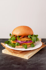 Chicken burger with arugula and red onion