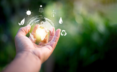 Hand holding virtual global with green background, energy saving concept, alternative and renewable...