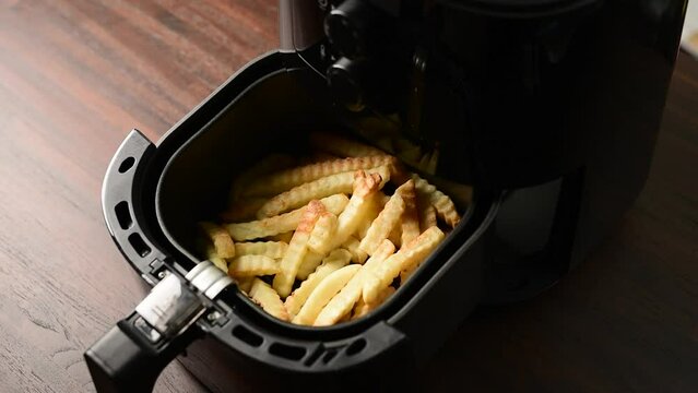 French fries in Air fryer,fried potatoes,cooking with hot air wedge potatoes,hand pulling open Air fryer oil-free frying pan