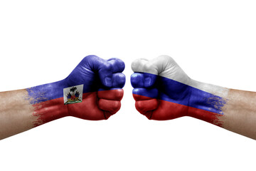 Two hands punch to each others on white background. Country flags painted fists, conflict crisis concept between haiti and russia