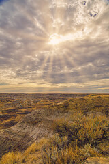 Sunrays breaking through clouds above badlands. 