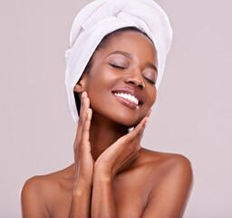 Love the skin youre in. An isolated studio shot of a beautiful young woman wearing a towel on her head.