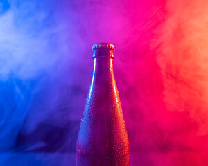 Glass bottle of beer in blue pink mist