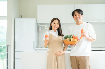 Obraz na płótnie Canvas 野菜を持つ妊婦と男性 