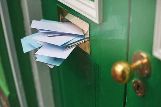An entranceway filled with envelopes. Cropped shot of letters in a letter box.