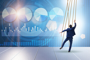 Businessman puppet being manipulated by ropes