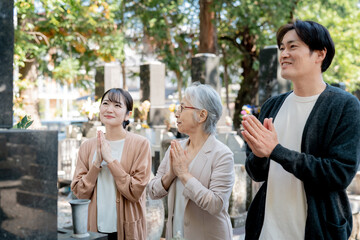 親子でお墓参りする（合掌）
