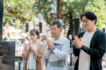 親子でお墓参りする（合掌）
