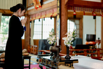 お葬式で焼香台に立つ女性（お焼香）
