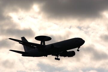 Silhouette of JASDF E-767 AWACS against the background of cloudy evening sky - obrazy, fototapety, plakaty