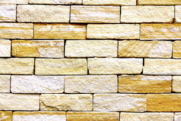 Yellow stone wall. Bright and symmetric sandstone background.   