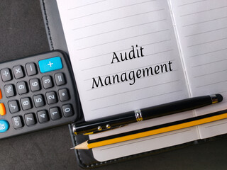 Top view calculator,pen and pencil written with text Audit Management on notebook.