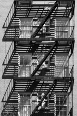 Crédence de cuisine en verre imprimé Gris foncé La sortie de secours de New York City photographiée en noir et blanc améliorant les ombres