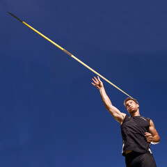this is going the distance. Shot of a lone man throwing a javelin outside.