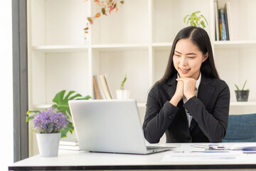 Pretty Asian woman working and typing on a laptop computer at the office. businesswoman looking at financial statistics data analysis chart graph profit growth business idea