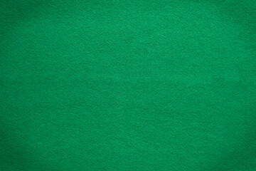 Poker table felt background in green color. There is a black vignette at the corner of the image. close up, texture, copy space, rummy