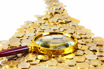 Pile of gold coins and magnifying glass background on a white backgrround. Money on white background. Copy space.Finance