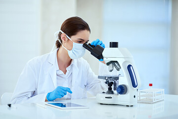 Determining the root cause of her latest medical case. Shot of a female scientist working alone in the lab.