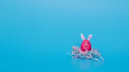 pink easter egg in the form of a hare on a blue background