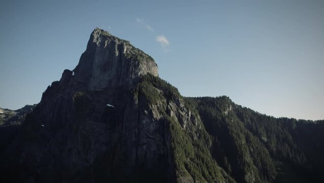 Drone Orbiting Tall Mountain Peak with Dramatic Steep Rock Cliffs