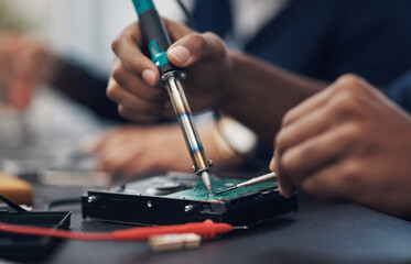 The master at making any computer hardware work. Shot of a technician using a soldering iron .to repair computer hardware.