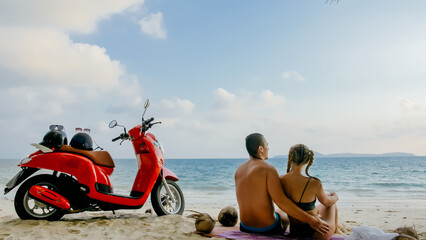 Scooter road trip. Lovely couple on red motorbike in white clothes on sand beach. Just married...