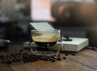Glass of black coffee put on wooden desk,