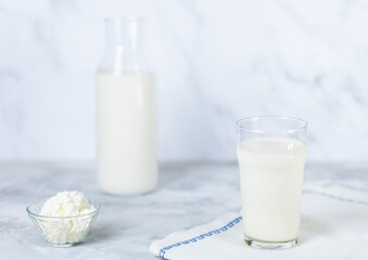 Homemade kefir, buttermilk or yogurt with probiotics. Yogurt with a glass bottle and a glass on a light background. Probiotic cold fermented milk drink.