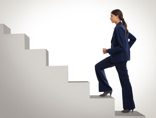 She wont stop still she gets to the top. Studio shot of a motivated businesswoman climbing a flight...