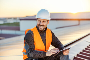 A happy worker using tablet on rooftop.