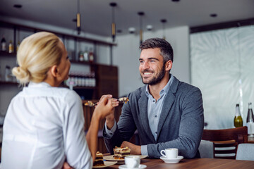 Couple eating cake at the coffee shop.