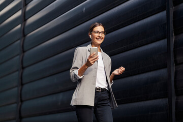 A businesswoman with a phone and earphones