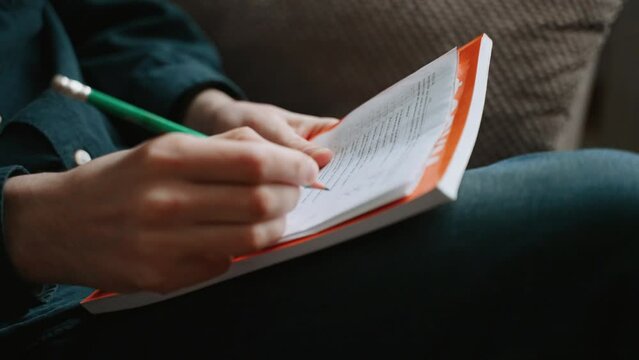 The person takes the survey test and holds a sheet of paper on his lap and marks it with a simple pencil. Pencil with graphite rod and eraser on the end