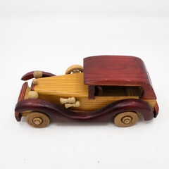 side view of an vintage model brown wooden toy car isolated in a white background