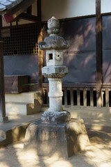 Naklejka premium 神社の境内に灯をともす石の灯篭