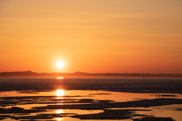 Fototapeta premium 氷が浮かぶ夕暮れの光る湖 