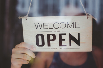 wooden door sign with the text "open" and the idea of ​​opening a small business activity again after the incident of Covid-19 ended the lock and went through a crisis.