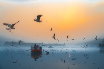 Sunrise in a river foggy morning with boat