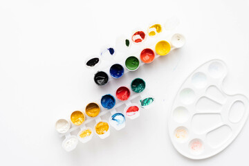 Flat composition a set of multi-colored paints in jars. Space for the text.