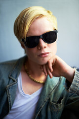 Naklejka premium Hes got attitude. Attractive young guy wearing hipster shades with his hand on his chin.