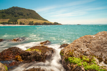 Mount Maunganui landmark on horizon from rocky foreground of Moturiki Island