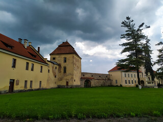 Fototapeta na wymiar Zhovkva Castle is an architectural monument of the Renaissance in the city of Zhovkva in Lviv region of Ukraine. view of the renaissance castle on cloudy summer day