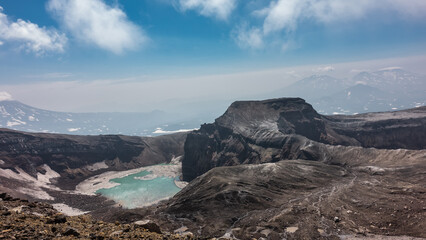 A lifeless acid lake on top of an active volcano. Snowmelt on the steep slopes of the crater and...