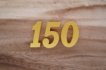 Golden Arabic numerals on real wood with brown and white pattern.
