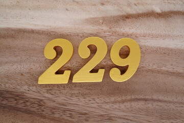 Golden Arabic numerals on real wood with brown and white pattern.